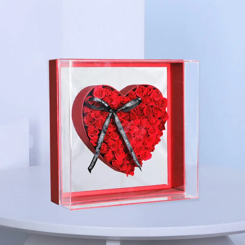01 A heart-shaped arrangement of red baby roses encased in a transparent box with a black ribbon.