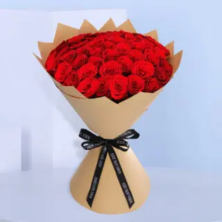 Valentines Day Home 34 A premium bouquet of red roses elegantly wrapped in brown paper and tied with a black ribbon.