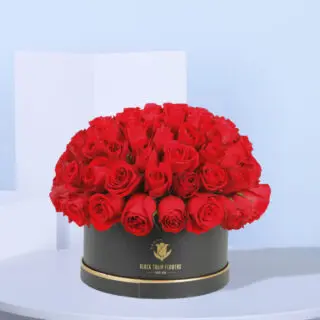 Luxurious 100 stem red roses arranged in a sleek round black box.
