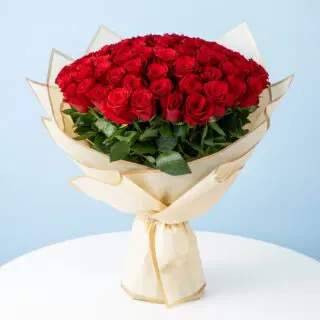 A 100 red roses bouquet wrapped in half white wrap.