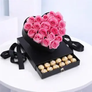 Pink roses arranged in a heart-shaped box with a drawer filled with Ferrero Rocher chocolates.