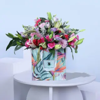A large bunch of colourful flowers in a tropical-themed bag.