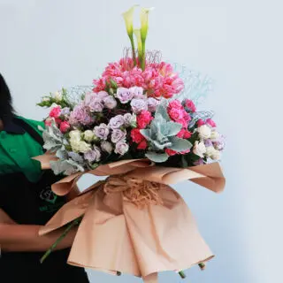 Mixed flowers bouquet wrapped in brown paper and tied with natural fiber.