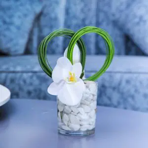 Centerpiece made with of Phalaenopsis White flower with white pebbles and green leaves