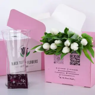 A bunch of 10 vibrant tulip stems in a pink box, accompanied by a stylish glass vase and a packet of flower food.