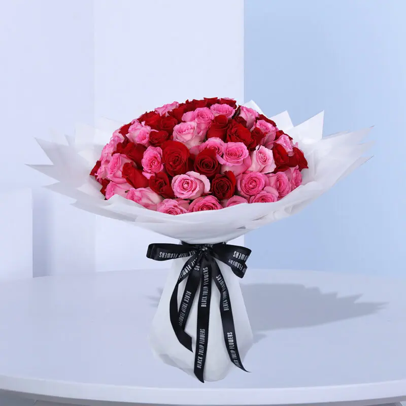 01 Elegant mix of red and pink roses, wrapped in white and tied with a black ribbon.