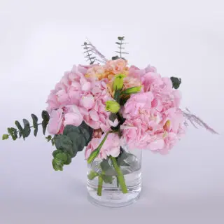 Pink hydrangea and eucalyptus arrangement in a glass vase