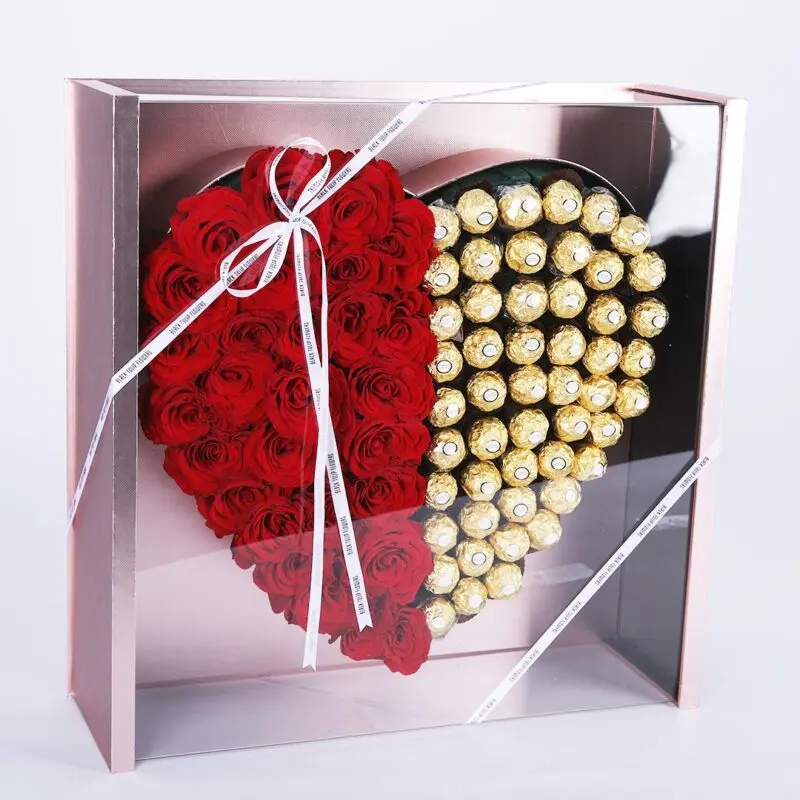 BT_FL_2406 A heart-shaped gift box with a transparent lid, featuring red roses on one side and Ferrero on the other, tied with a red ribbon.