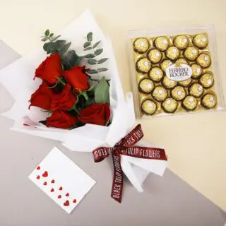 Bouquet of red roses tied with a maroon ribbon with a Ferrero box and message card.