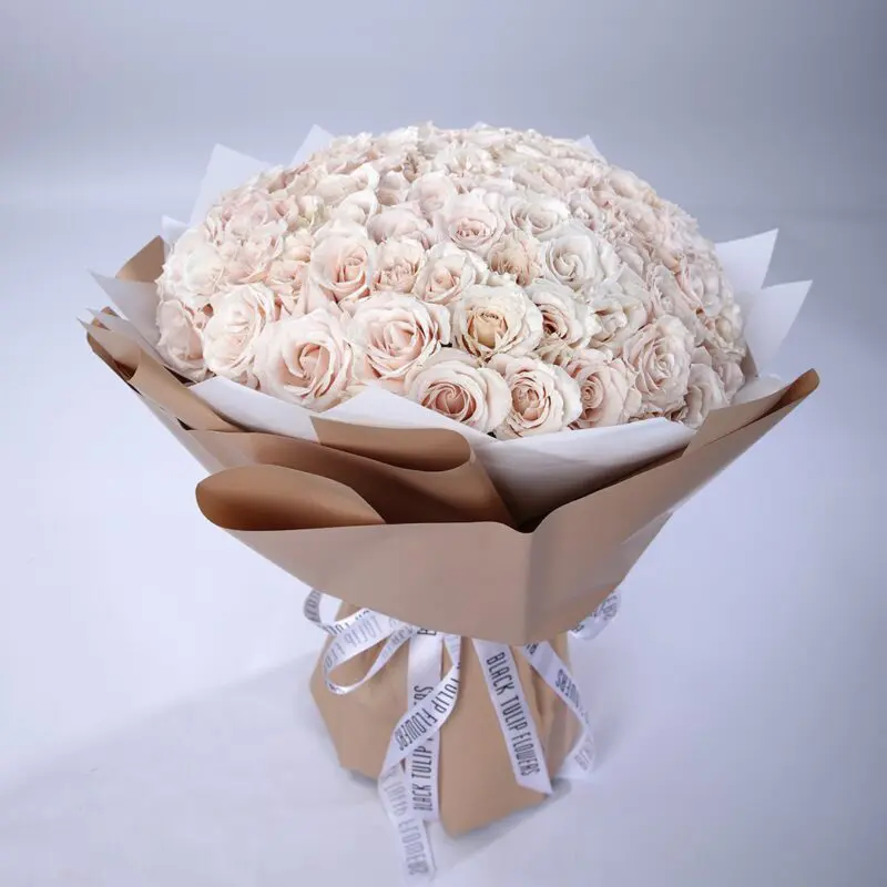 Creamy Bouquet (1) Luxurious bouquet of 100 creamy white roses wrapped in brown paper tied with white ribbon.