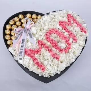 Heart-shaped box with chocolates and "Mom" spelled out with pink roses.