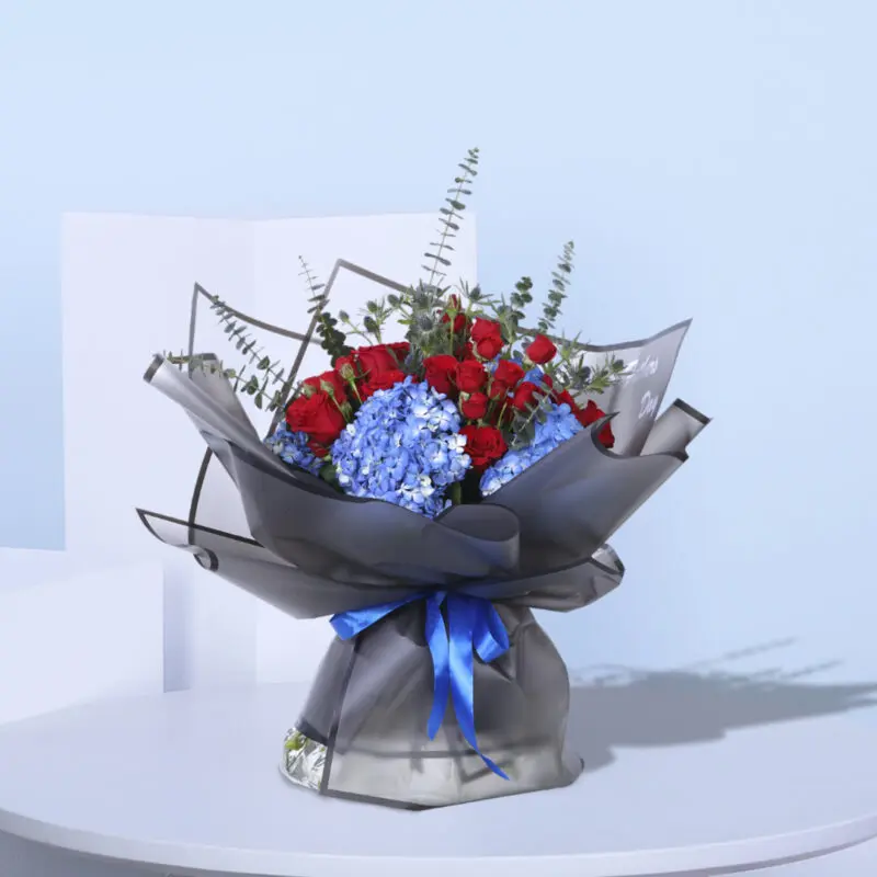 1 (20) Stunning floral gift of red roses and blue hydrangeas, wrapped in black paper with a blue ribbon