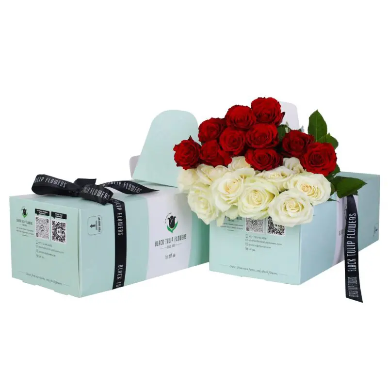 A bunch of 5 red roses and 5 white roses in a green box, tied with a black ribbon, and accompanied by flower food.