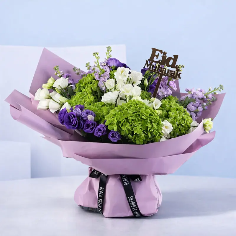 holy-eid-bouquet-2026 A vibrant Eid bouquet featuring Purple Matthiola, Green Hydrangea, and Lisianthus, topped with an Eid Mubarak acrylic stick.