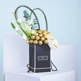 A easy-to-carry black flower box arrangement with white tulips, white anthuriums, eucalyptus, and Ferrero Rocher chocolates.