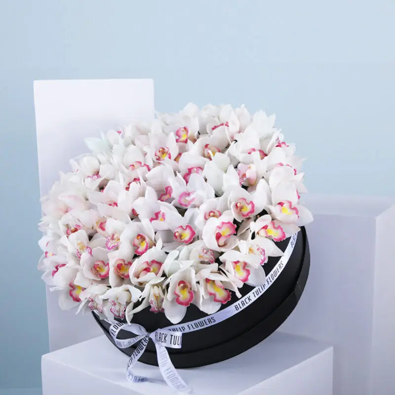 01 White orchid arrangement in a round black hat box.