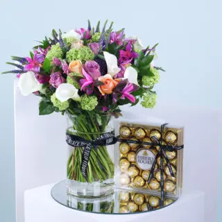 Mixed flowers in glass vase with Ferrero Rocher