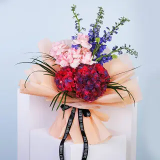 Vibrant hydrangea bouquet in peach wrapping paper.