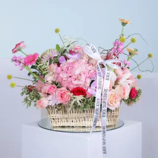 Vibrant flower arrangement in a wicker basket.