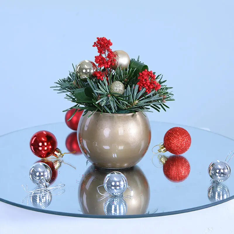 01 A silver-colored bowl filled with lush Christmas florals, featuring pines and ferns, perfect for holiday decor.