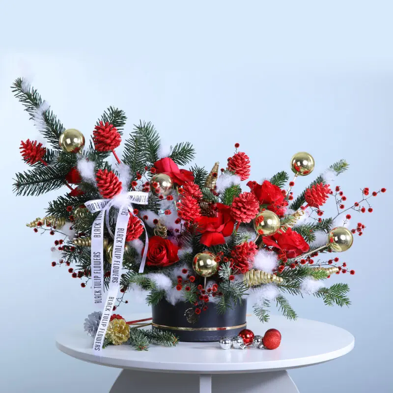 A black hat box adorned with seasonal florals and Christmas decorations, embodying the spirit of the holiday season.