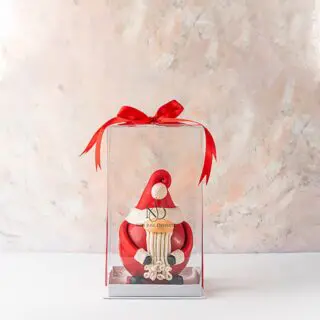 A charming 3D Santa with a long beard, weighing 800 grams in red chocolate, paired with an assortment of milk chocolate truffles.