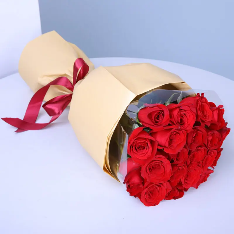 01 20 vibrant red roses wrapped in soft peach paper and finished with a maroon ribbon.