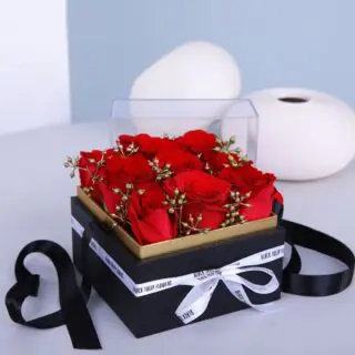 Stunning red roses, elegantly arranged in a clear acrylic box and tied with a delicate white ribbon.