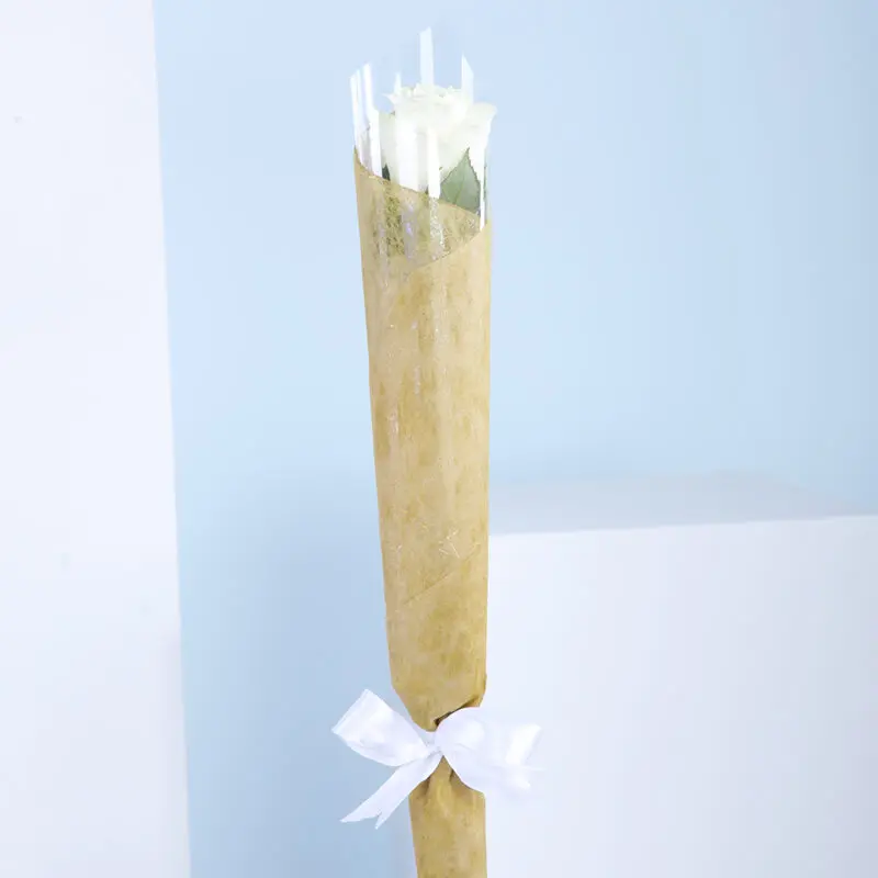 01 A bouquet of a single white roses wrapped in brown paper with a white ribbon.