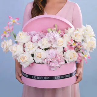 An elegant centerpiece showcasing an array of pastel flowers in a stylish box, perfect for a serene setting.