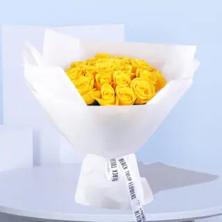 Close-up of a yellow rose bouquet, 20 stems wrapped in white paper with a white ribbon for a stylish finish