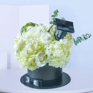 White graduation flower box with Hydrangea, Polister, Phalaenopsis bloom, and Eucalyptus
