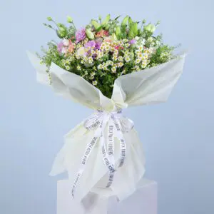 A large, colorful bouquet featuring pink gerberas, pink roses, white ohara, tanacetrum, bublurium, white lilies and more