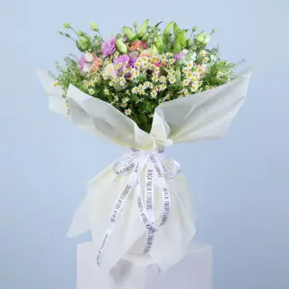 A large, colorful bouquet featuring pink gerberas, pink roses, white ohara, tanacetrum, bublurium, white lilies and more