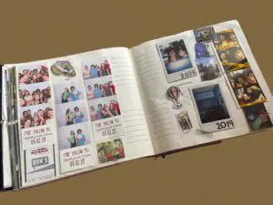 An open scrapbook filled with photos, mementos, and notes