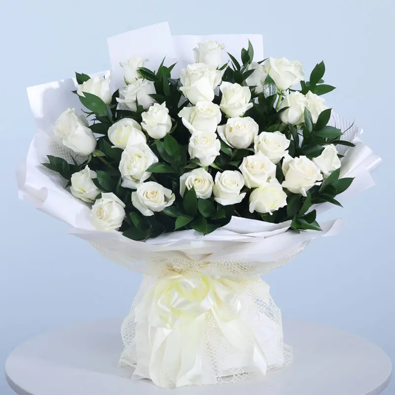 Sophisticated White Roses Bouquet of 30 white roses with fresh green leaves in a white wrap and tied with a white ribbon.