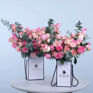 Mixed rose combo featuring pink, Jumelia, and baby roses with fresh eucalyptus in an elegant box.