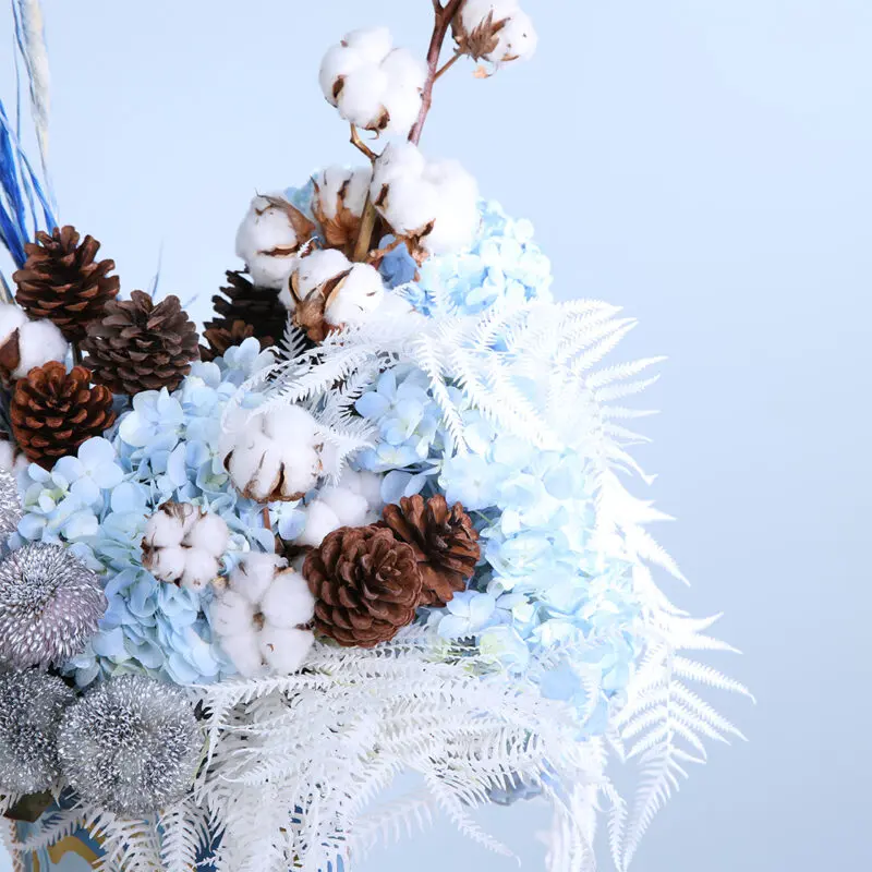 02 - Vibrant Blue Centerpiece Decorative centerpiece of blue hydrangeas, pine cones, cotton, and dry feathers with ping pong balls.