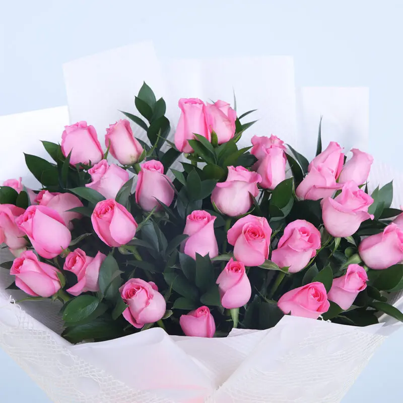 02 - Pretty Pink Rose Bouquet Close-up of a bouquet with 30 pink roses and lush foliage in a white wrap.