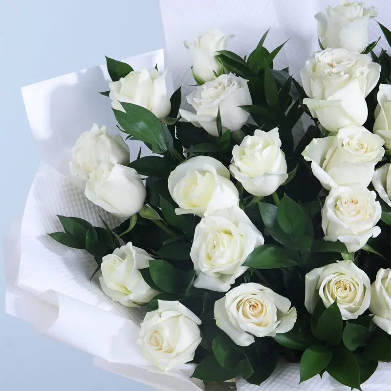 03 - Sophisticated White Roses Close-up of a luxurious bouquet featuring 30 white roses and leaves in a white wrap.