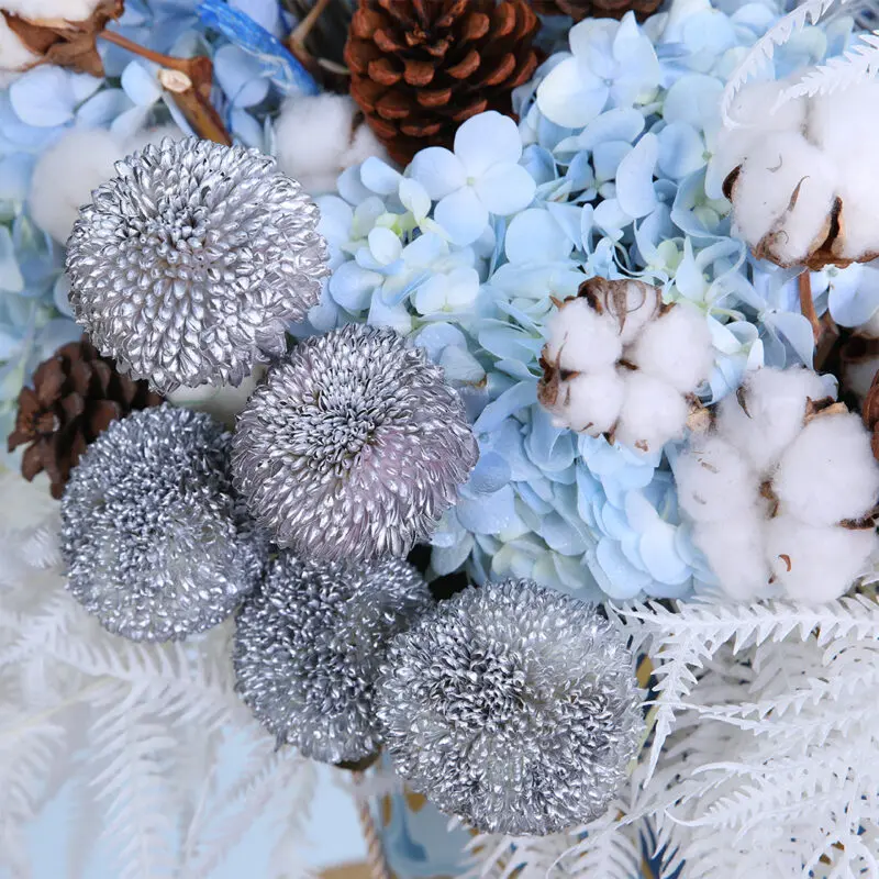 04 - Vibrant Blue Centerpiece Flower arrangement showcasing blue hydrangeas, pine cones, cotton, and ping pong balls with dry feathers.