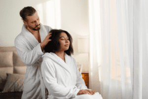 A couple relaxing on a couch, giving each other massages