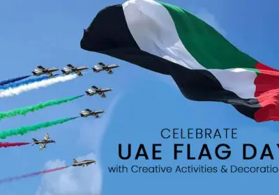 A large UAE flag waving in the wind against a blue sky, with several fighter jets flying in formation below, leaving colorful smoke trails. The text "CELEBRATE UAE FLAG DAY with Creative Activities & Decorations" is superimposed on the image.
