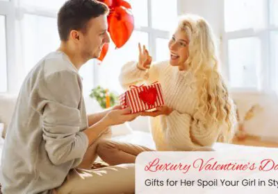 A couple sitting close together, exchanging gifts and smiling.