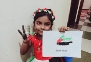 A photo of a person holding a flag of the United Arab Emirates, with the text "I love UAE" written on it.