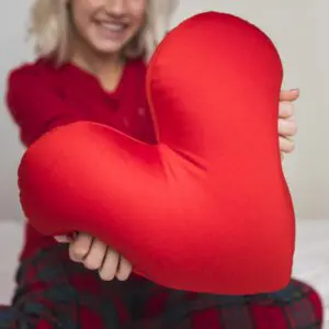 woman-hugging-heart-pillow-valentines-day-scaled