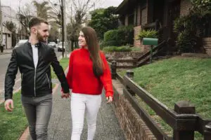 young couple holding hands as the walking in the street