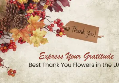 A festive autumnal arrangement with red berries, pinecones, and colorful leaves. A small, brown tag with the words "Thank You!" is attached to the arrangement. The text "Express Your Gratitude" and "Best Thank You Flowers in the UAE" is displayed below.