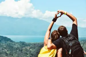 A couple hiking in nature, holding hands and smiling