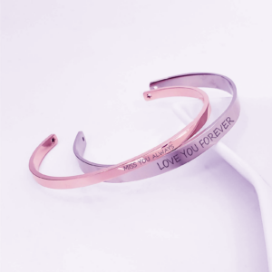 Two matching bracelets, one gold and one silver, with engraved messages. The gold bracelet reads "Love You Forever" and the silver bracelet reads "Miss You Always."